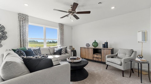 Kennebec Bellamy Model Home Living room with 52" ceiling fan and 2 large windows.