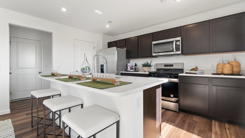 Kennebec Bellamy Model Home Kitchen with ample seating at the island and dark sarsparilla cabinetry.