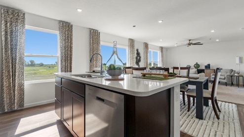 Kennebec Bellamy Model Home Kitchen island with sink and stainless steel dishwasher with extra storage in cabinetry