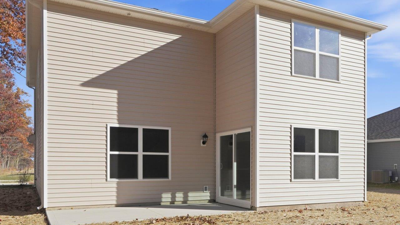pine rear exterior with patio and tree lined backyard