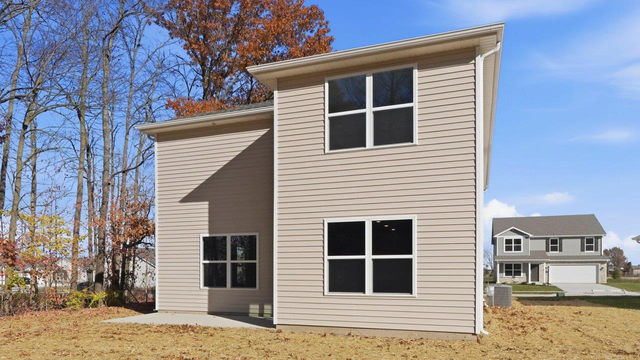 pine rear exterior with patio and tree lined backyard
