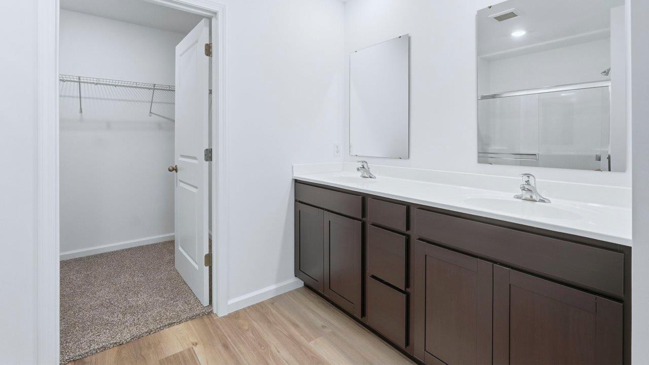 primary ensuite bathroom with dual sinks and walk in shower