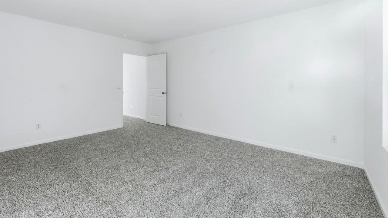 primary bedroom with carpet and ensuite bath and walk in closet