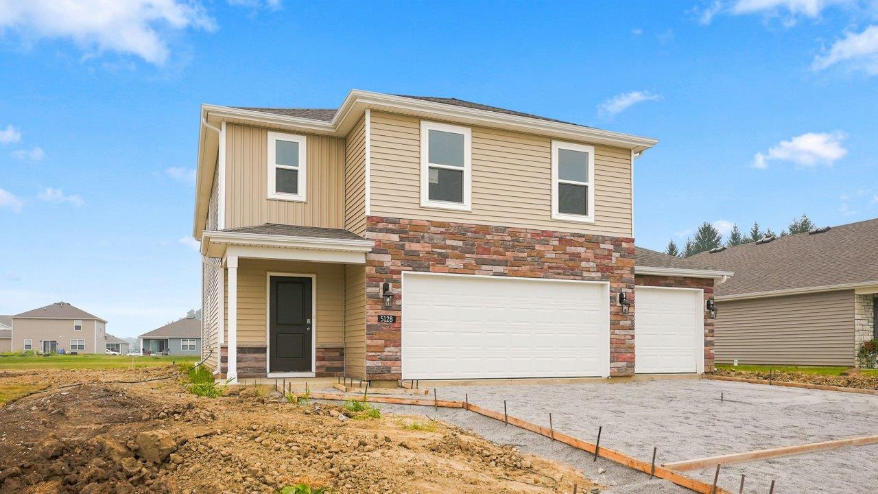kennebec elm c3 exterior with 3 car garage weathered edge petosky stone, wicker vinyl siding, and wicker board and batton