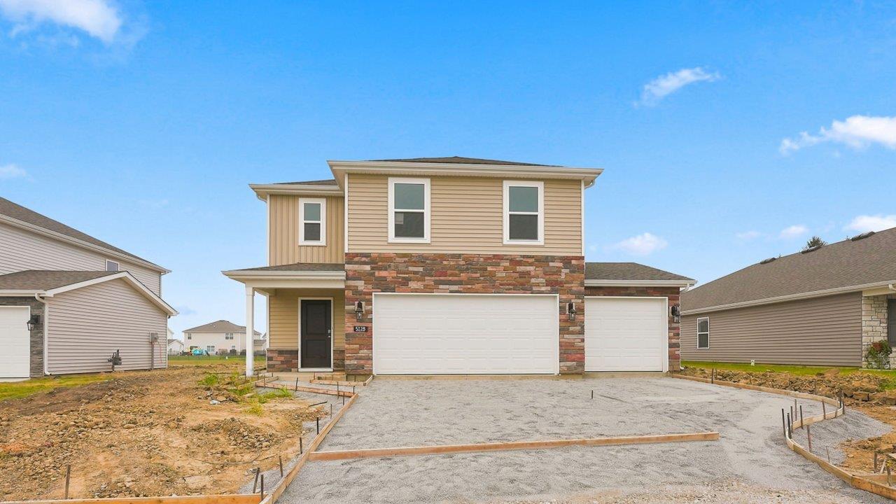 kennebec elm c3 exterior with 3 car garage weathered edge petosky stone, wicker vinyl siding, and wicker board and batton