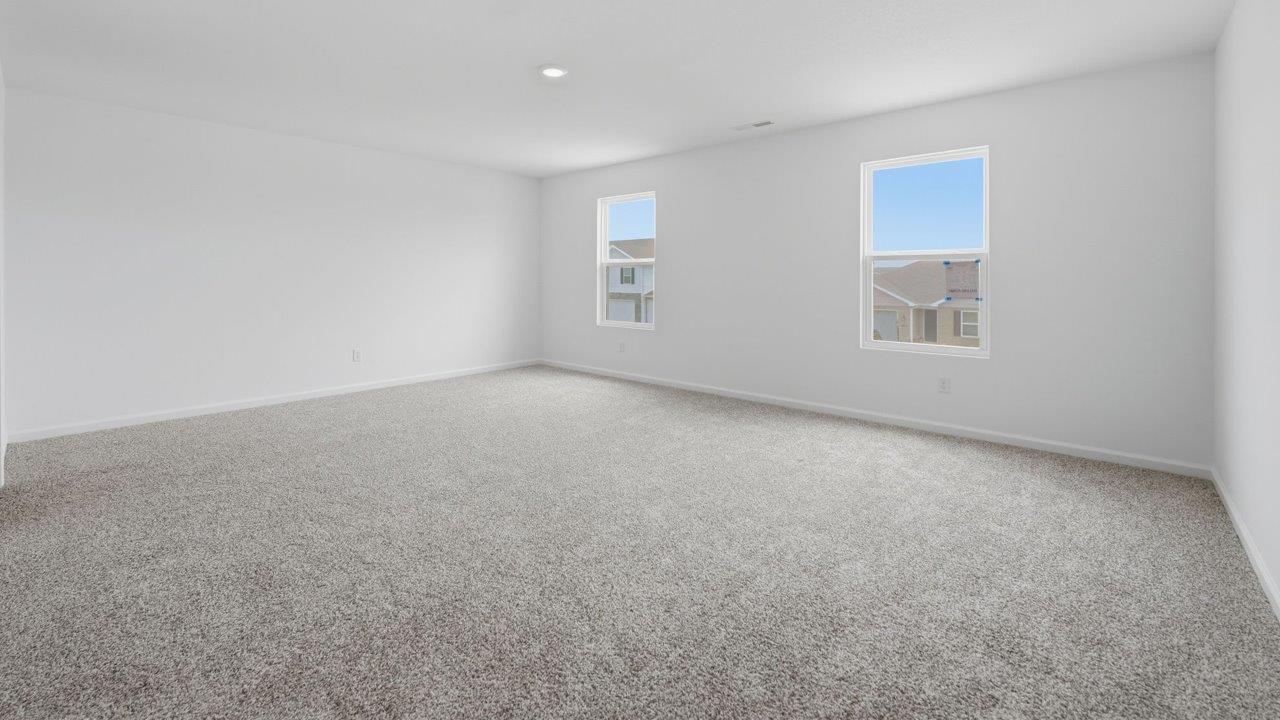 kennebec elm primary bedroom with carpet flooring, white walls, and ensuite bathroom and walk in closet
