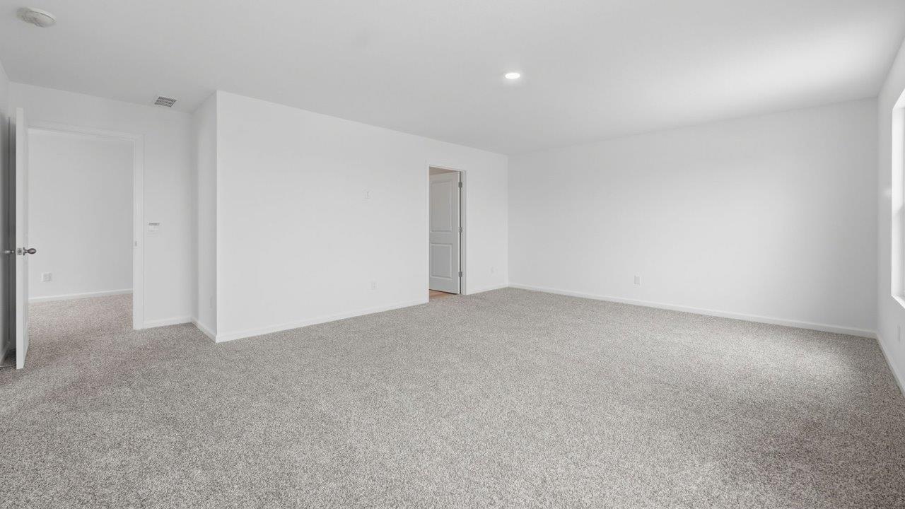 kennebec elm primary bedroom with carpet flooring, white walls, and ensuite bathroom and walk in closet