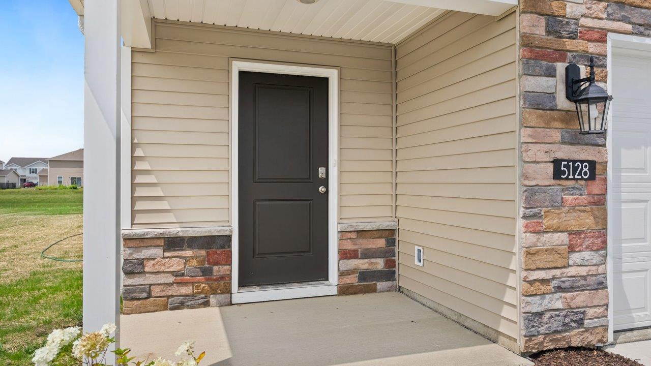 Kennebec Elm C3 - exterior with covered porch, 3 car garage, sod, and landscaping