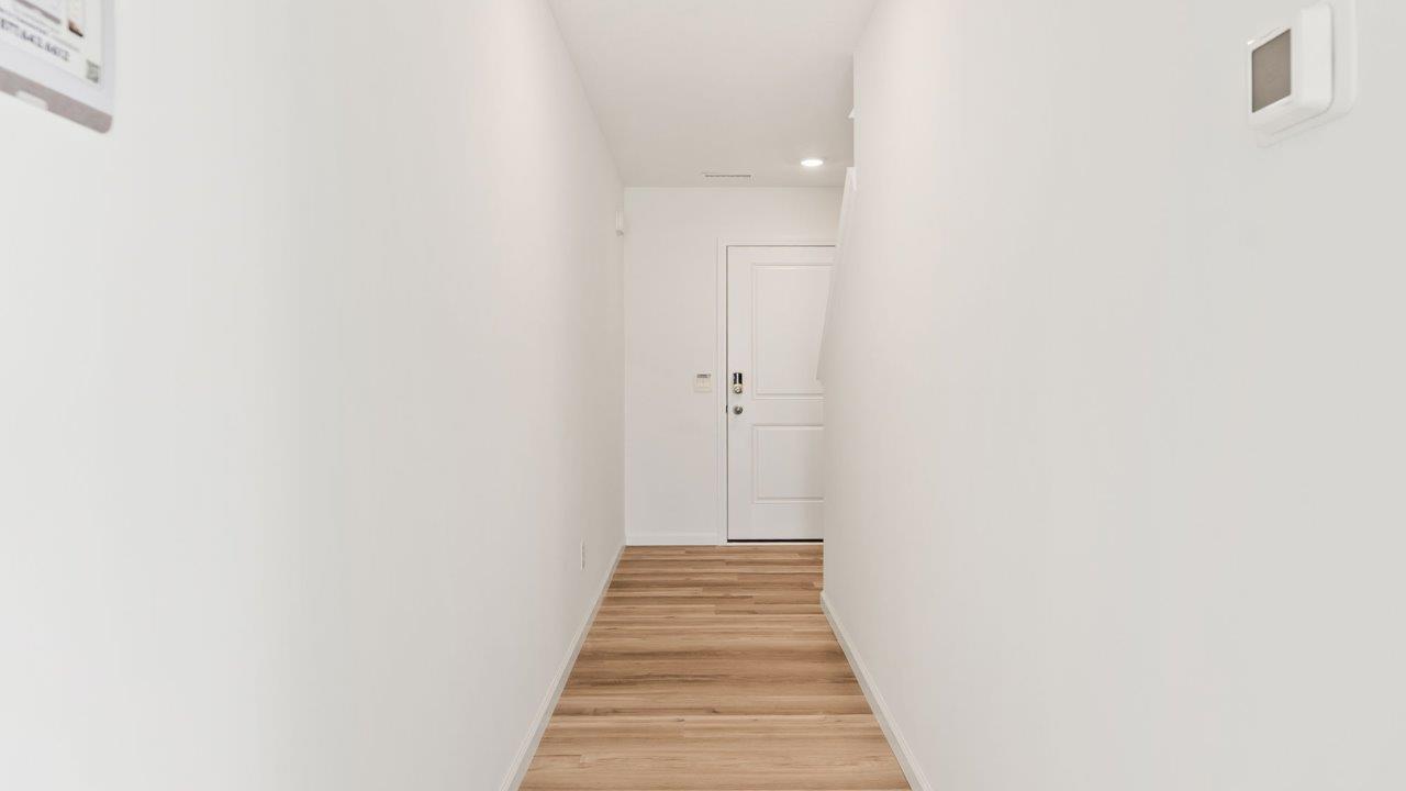 Kennebec Elm C3 - foyer with lvp flooring and white walls, leading into open layout living room and kitchen