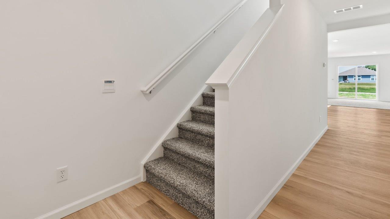 Kennebec Elm C3 - foyer with lvp flooring and white walls, leading into open layout living room and kitchen