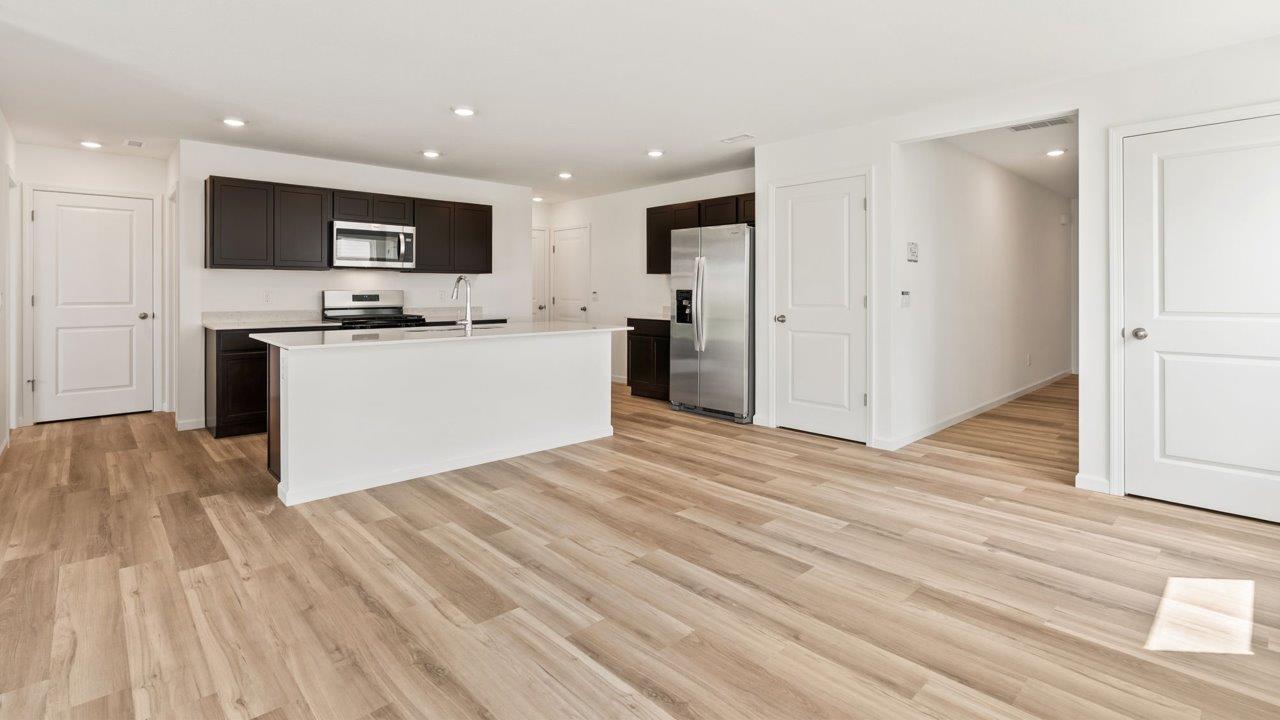 Kennebec Elm C3 - kitchen with sarsaparilla cabinets, quartz countertops, island with bar seating, and stainless steel appliances