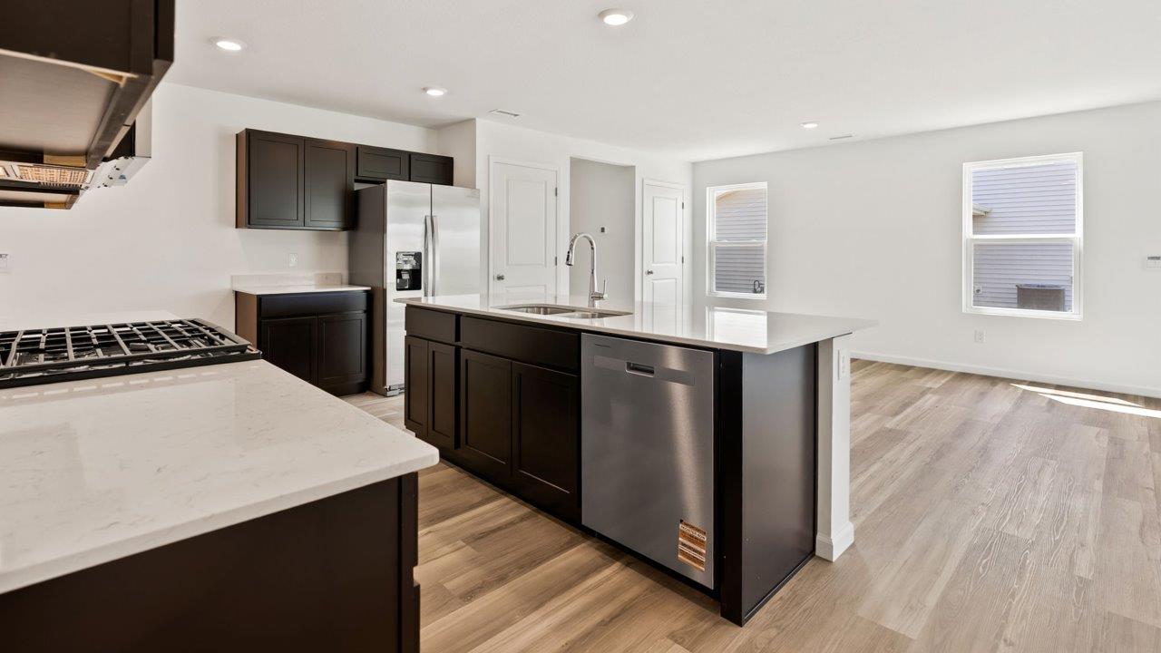 Kennebec Elm C3 - kitchen with sarsaparilla cabinets, quartz countertops, island with bar seating, and stainless steel appliances