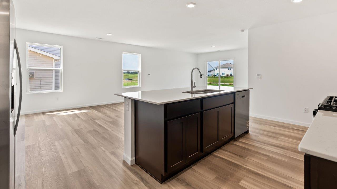 Kennebec Elm C3 - kitchen with sarsaparilla cabinets, quartz countertops, island with bar seating, and stainless steel appliances