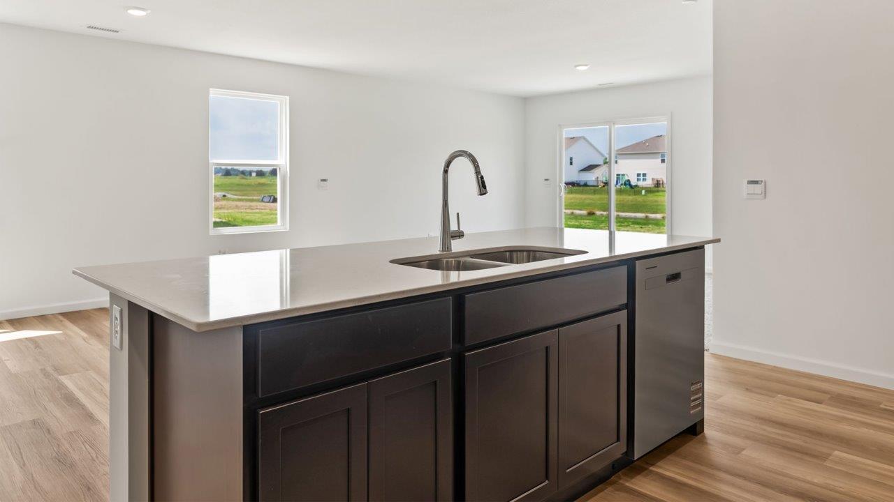 Kennebec Elm C3 - kitchen with sarsaparilla cabinets, quartz countertops, island with bar seating, and stainless steel appliances