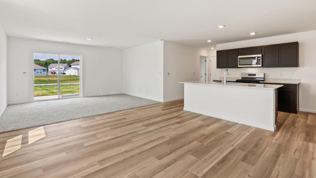 Kennebec Elm C3 - kitchen with sarsaparilla cabinets, quartz countertops, island with bar seating, and stainless steel appliances