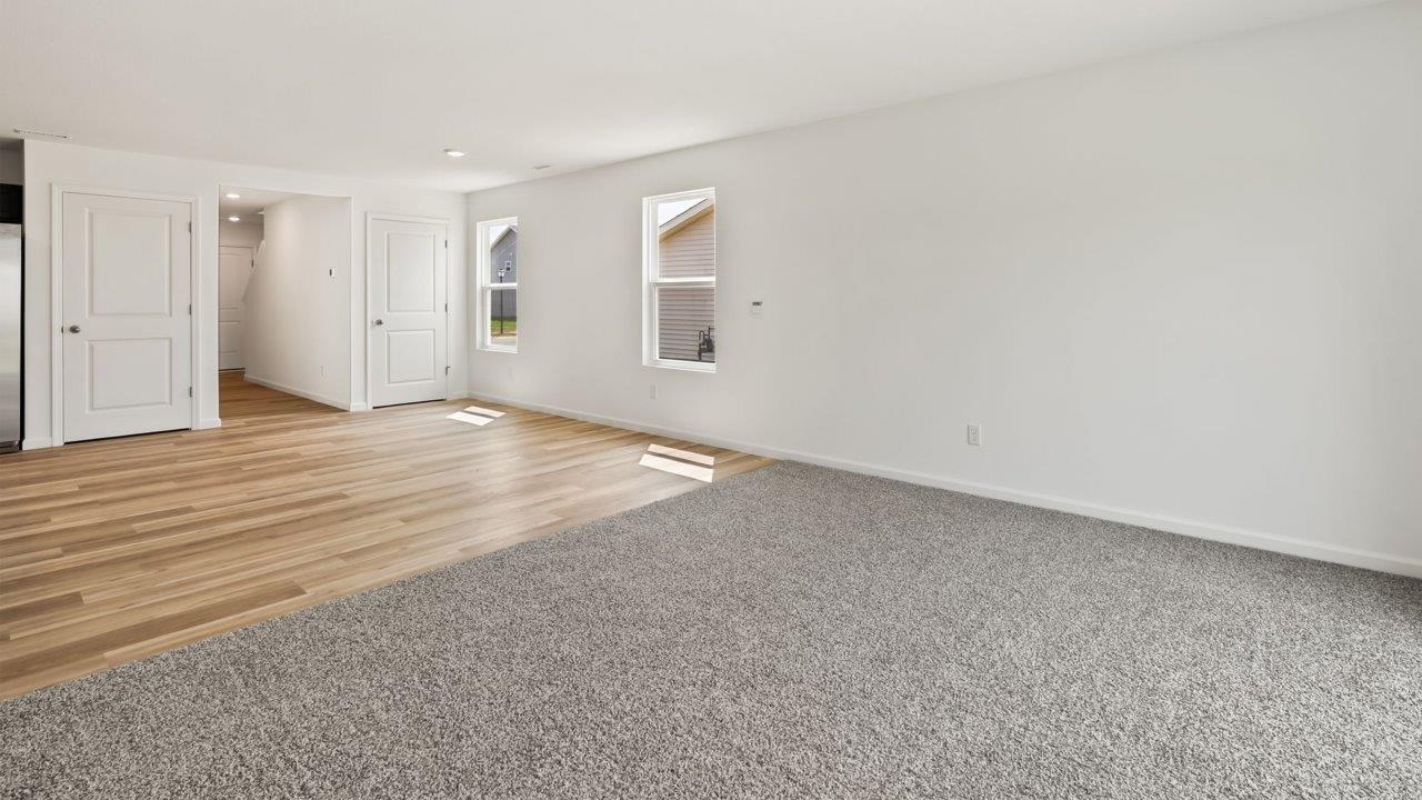 Kennebec Elm C3 - open layout living room with carpet flooring and sliding glass door to backyard patio
