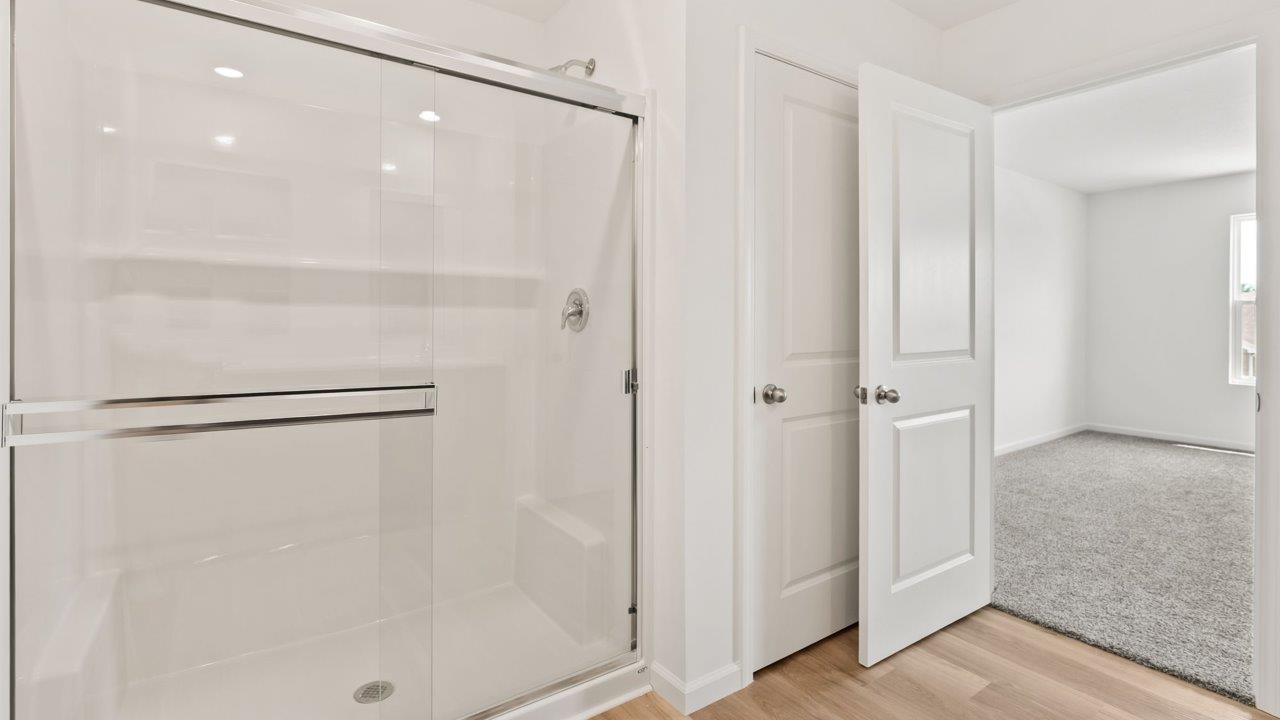 Kennebec Elm C3 - primary bedroom ensuite bathroom with dual sinks, walk in shower, linen closet, and sarsaparilla cabinets