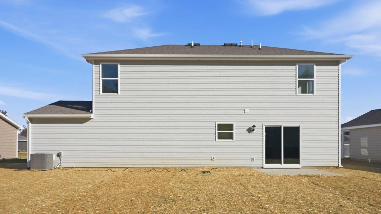 fairton rear exterior with patio and tree lined backyard