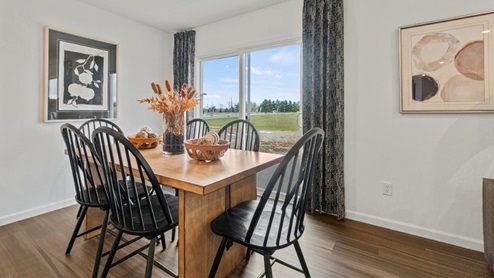 Riverwalk Villas Aldridge Model Home - Dining table area with sliding glass door leading to the backyard.
