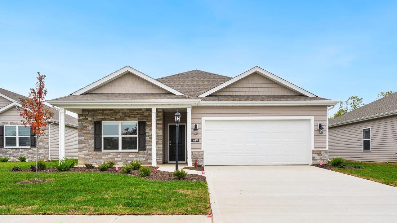 riverwalk villas harmony b3 exterior with covered patio, 2 car garage, sod yard, landscaping, heather vinyl siding, heather shake, and glacial bluff stone