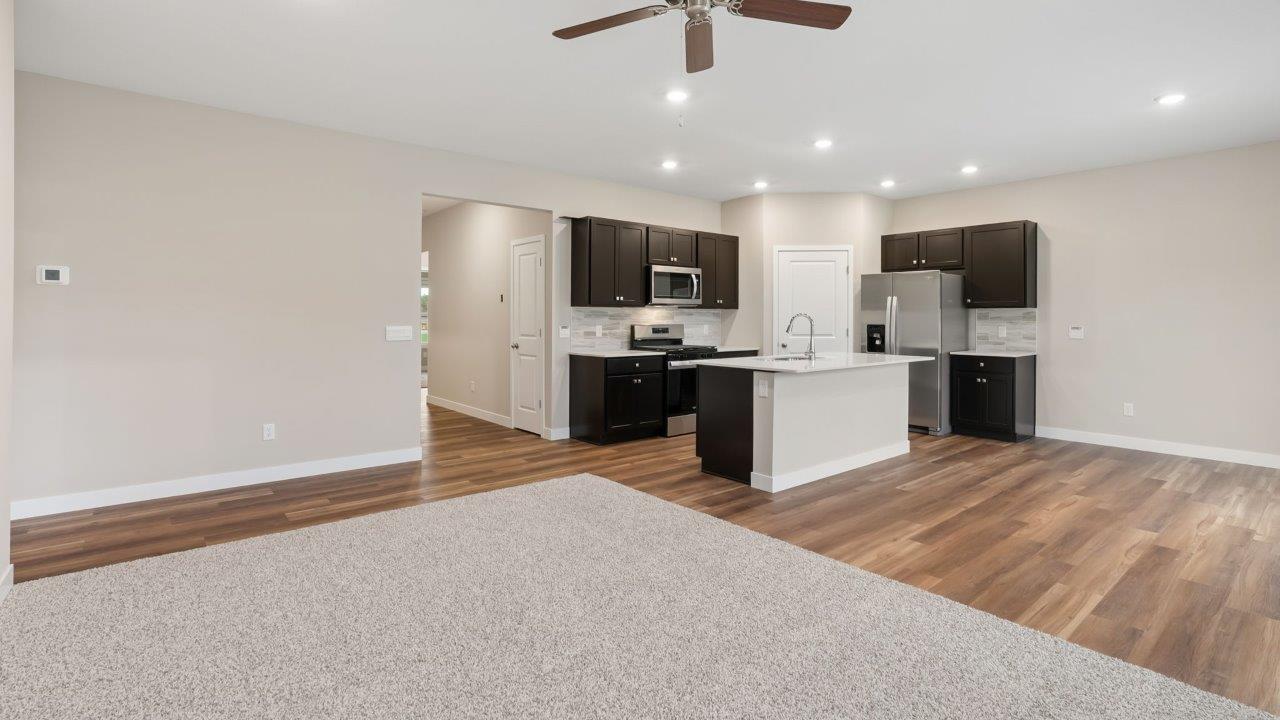 riverwalk villas harmony b3 kitchen with miami vena quartz countertops, sarsaparilla cabints, whirlpool stainless steel appliances, corner pantry, and ceramic tile backsplash