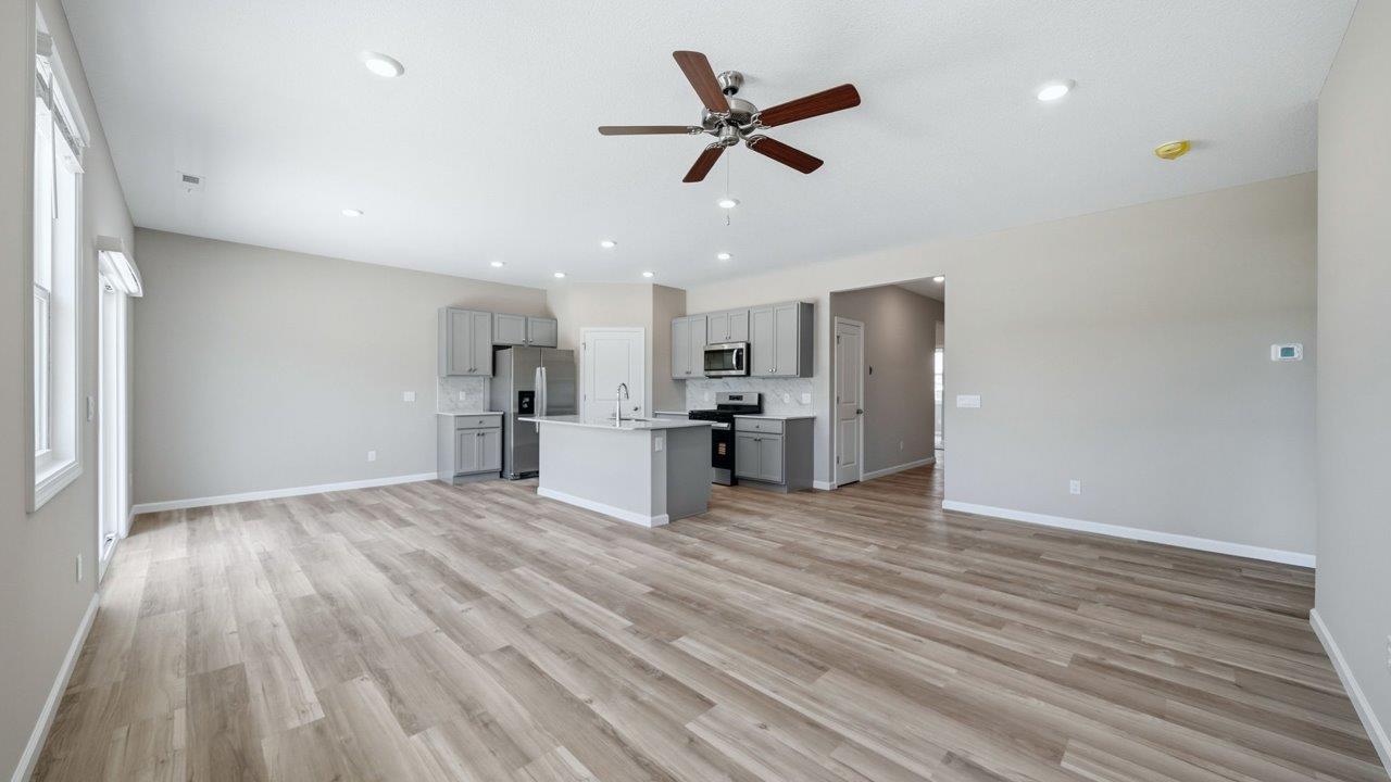 open layout living room, dining space, and kitchen with lvp throughout