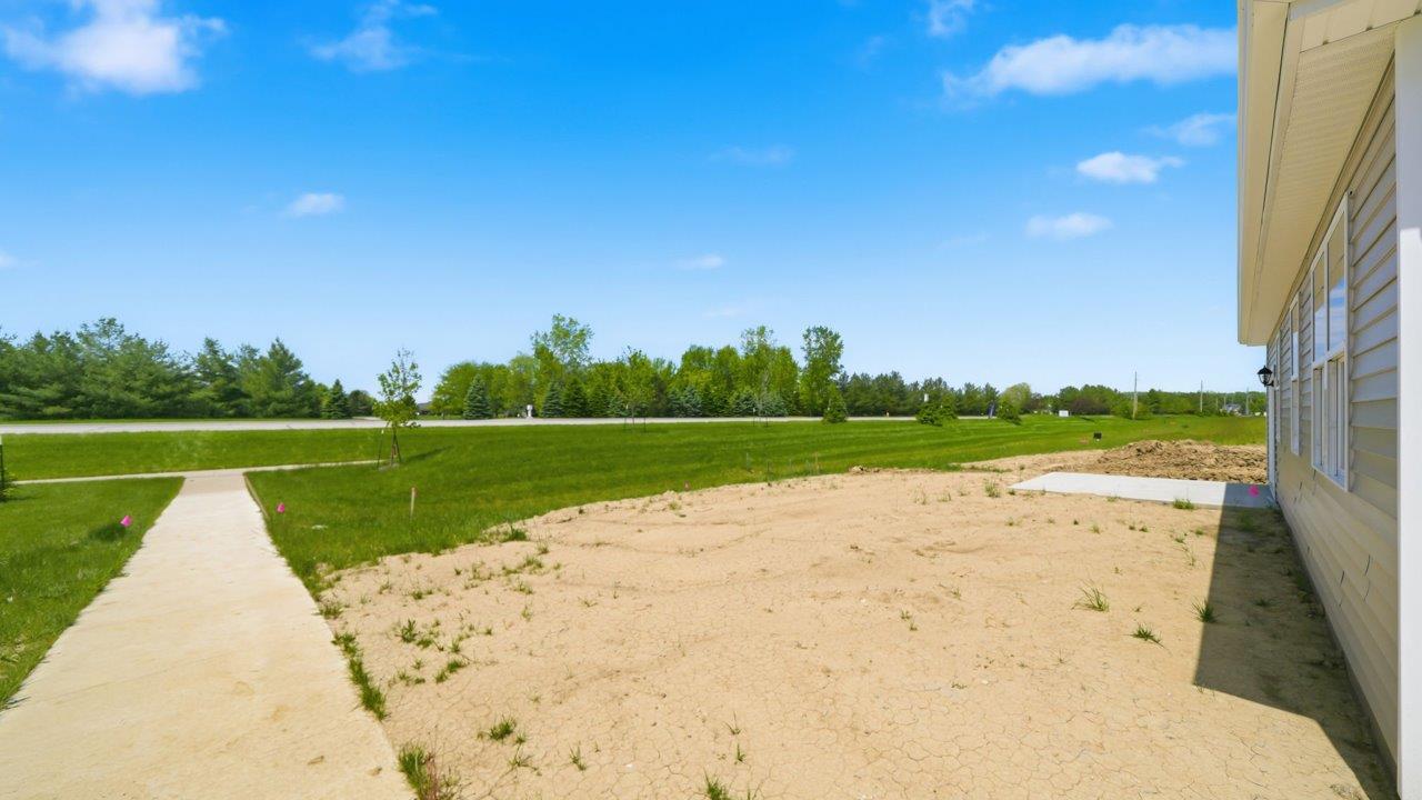 spacious backyard and concrete patio with pond