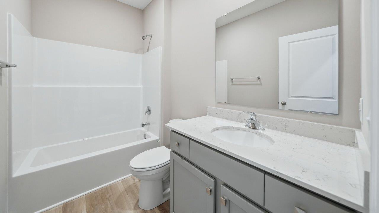 full bathroom with tub shower and single sink vanity