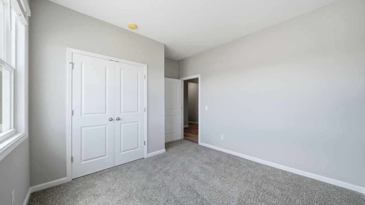 bedroom 3 with carpet flooring, 2 windows, and ensuite closet