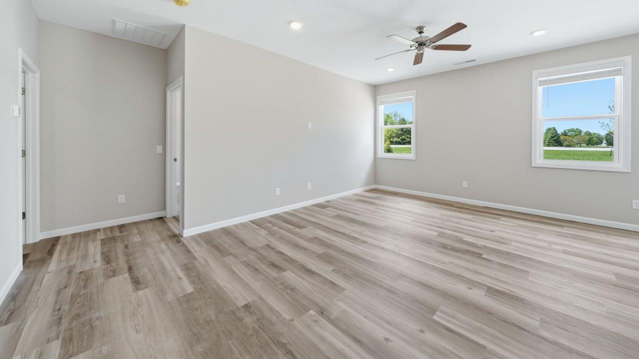 foyer leading into open layout living room with lvp flooring and large windows