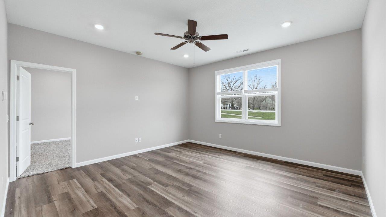 open layout living room with lvp flooring, ceiling fan, and 2 windows