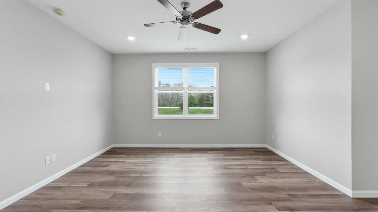 open layout living room with lvp flooring, ceiling fan, and 2 windows