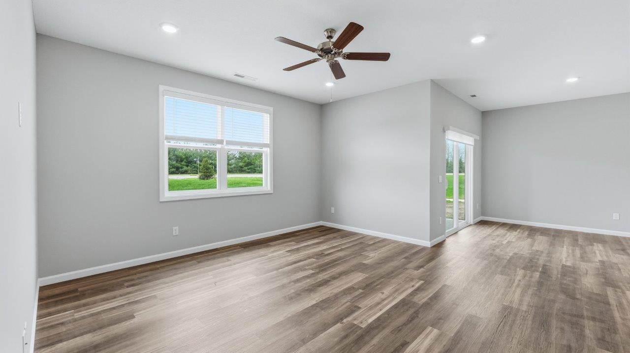 open layout living room with lvp flooring, ceiling fan, and 2 windows