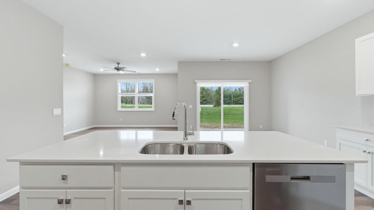 kitchen with white cabinets, stainless steel appliances, corner pantry, center island with bar seating, tile backsplash