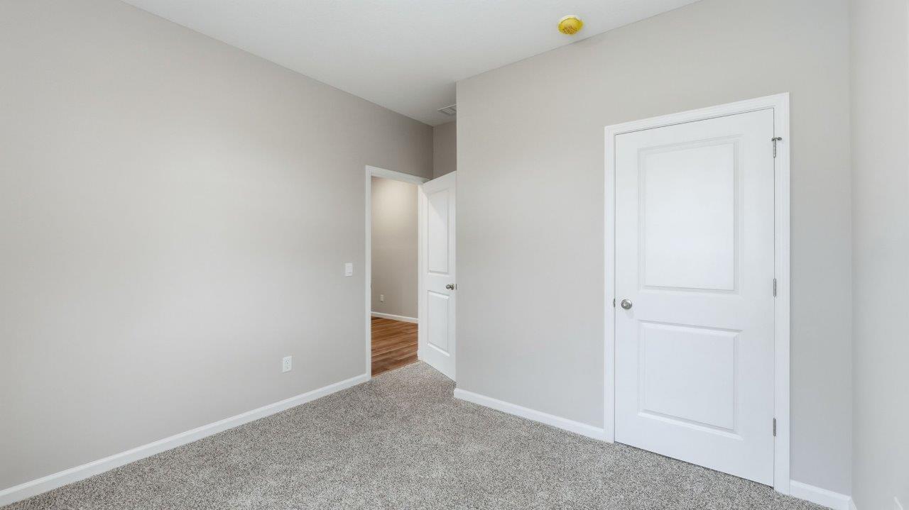 bedroom 3 with carpet, closet, and 2 windows