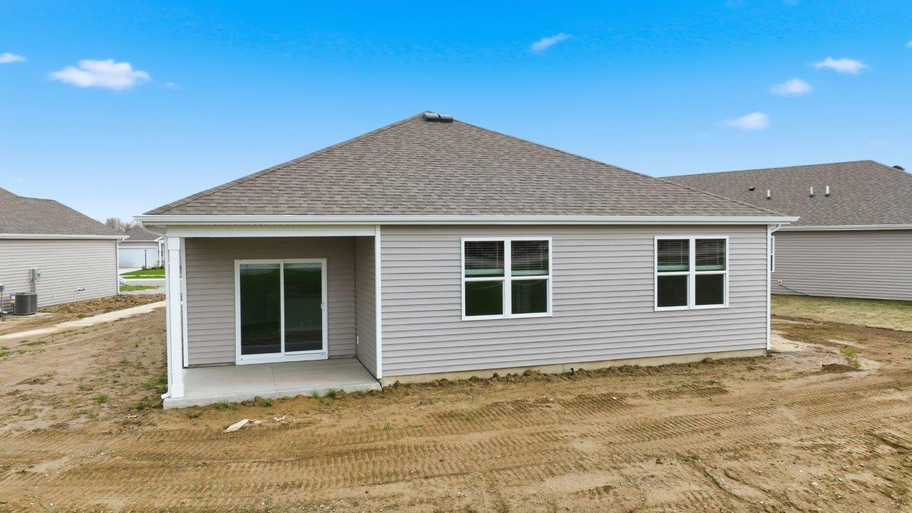 riverwalk villa rear exterior with covered back patio and pond