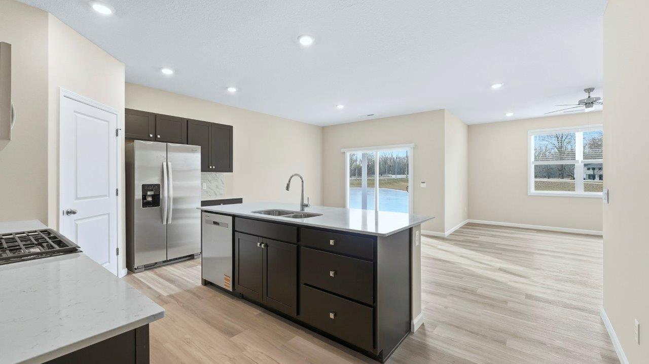 kitchen with sarsaparilla cabinets, tile backsplash, corner pantry, stainless steel appliances, and center island