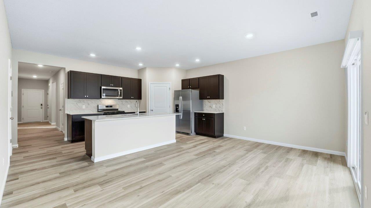 kitchen with sarsaparilla cabinets, tile backsplash, corner pantry, stainless steel appliances, and center island