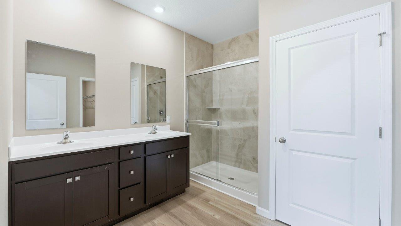 primary ensuite bathroom with dual sinks, tile shower, and private water room