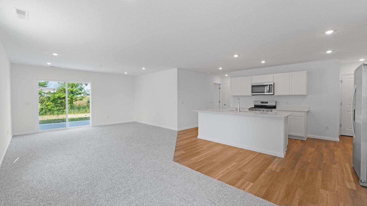 elm open concept living room, kitchen, and dining with carpet and lvp