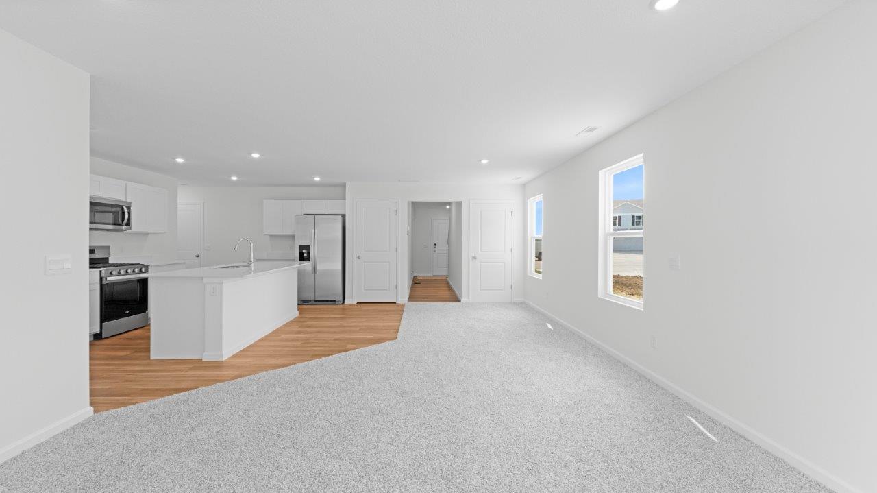 elm living room with carpet flooring and sliding door to backyard