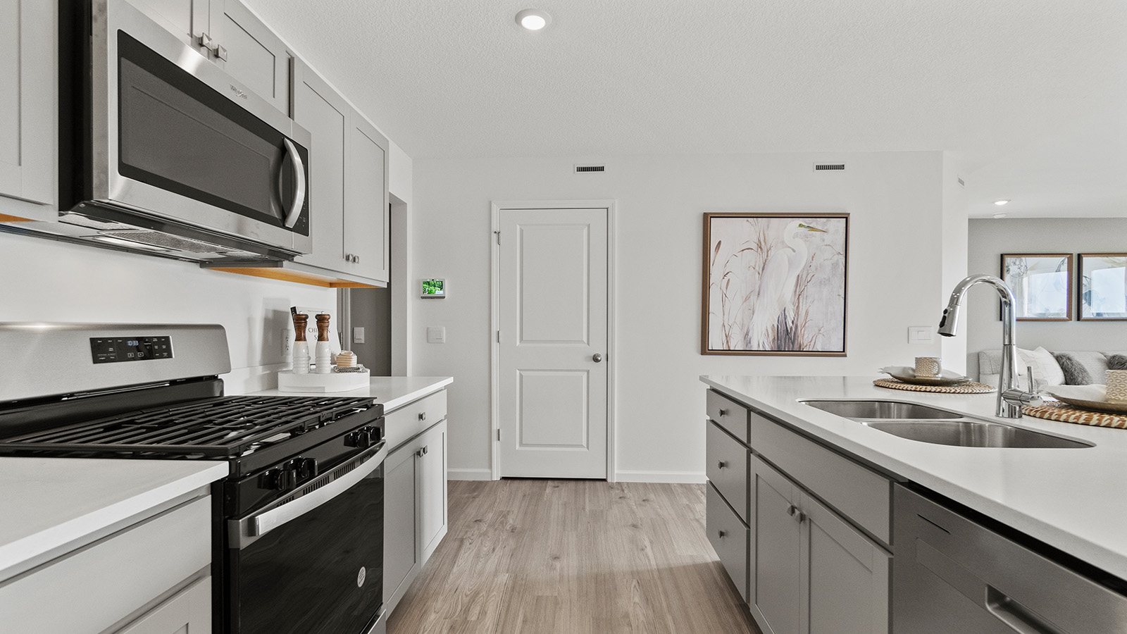chatham kitchen with grey cabinets, quartz, center island with bar seating, and stainless steel appliances