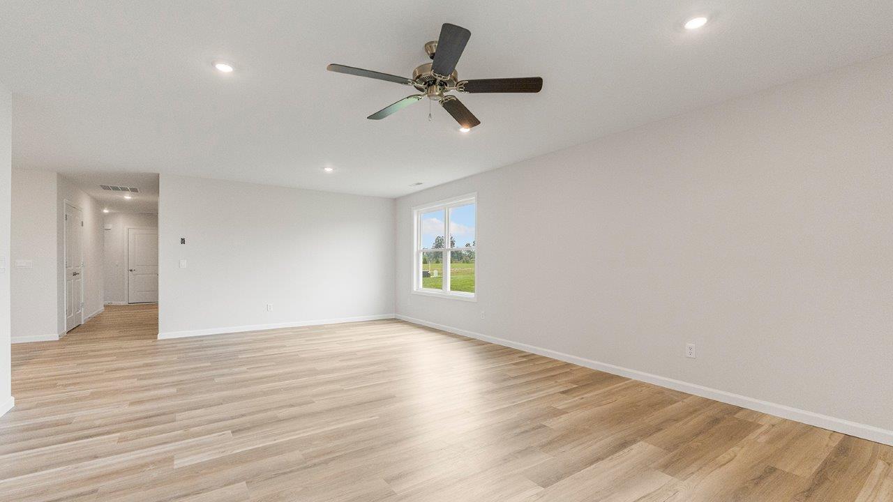 living room open floorplan with mohawk avery lvp flooring, ceiling fan, and windows