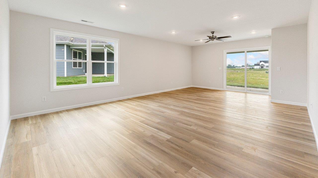 living room open floorplan with mohawk avery lvp flooring, ceiling fan, and windows