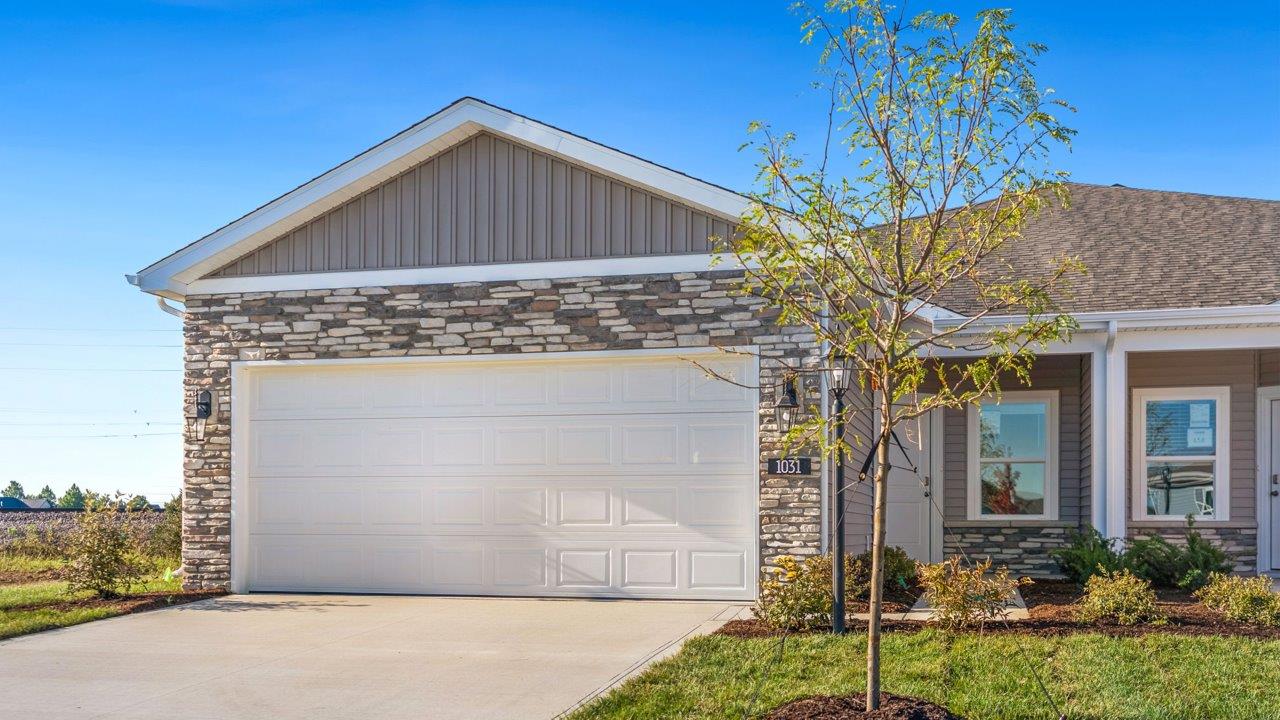 livingston lakes paired villas olsen plan exterior with sodded yard, landscaping, covered front door patio, and stone exterior