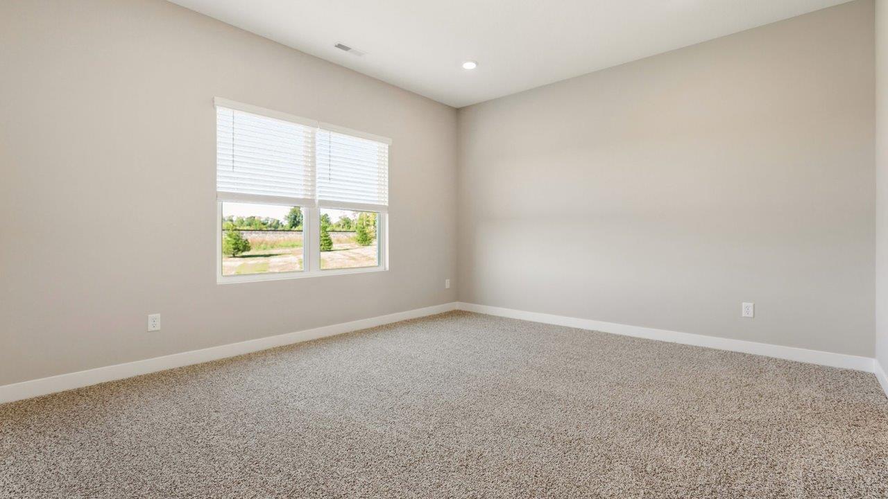 livingston lakes paired villas olsen primary bedroom with beige carpet flooring, 2 large windows, and ensuite bathroom and walk in closet