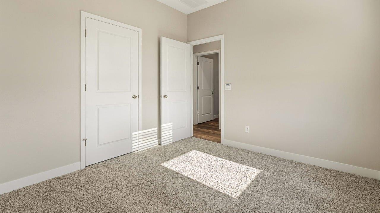 livingston lakes paired villas olsen bedroom 2 with beige carpet, ensuite closet, and single window