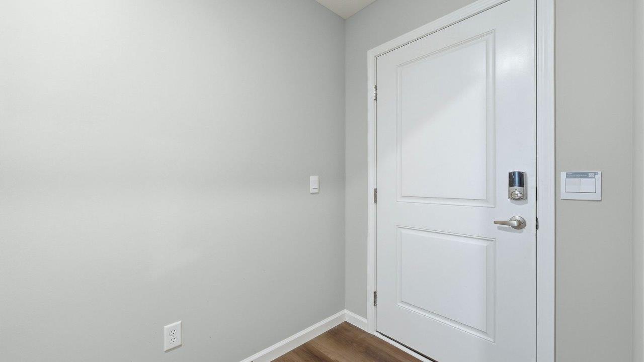 front door and foyer with lvp flooring and popular grey walls