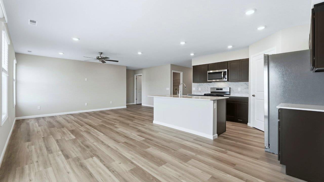 open layout living room, kitchen, and dining spaces connected with lvp flooring