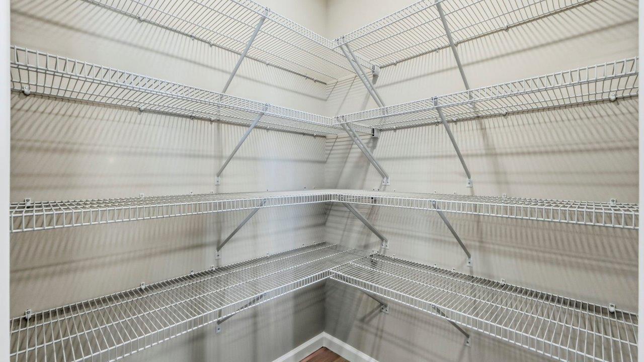 spacious corner pantry with shelving built-in